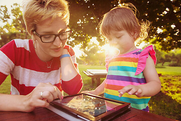 Image showing mom and her little daughter using tablet computer