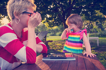 Image showing mom and her little daughter using tablet computer