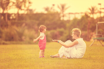 Image showing mother and little daughter playing at backyard