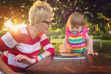 Image showing mom and her little daughter using tablet computer