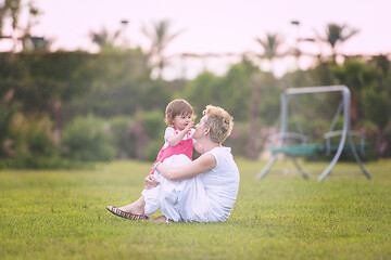 Image showing mother and little daughter playing at backyard