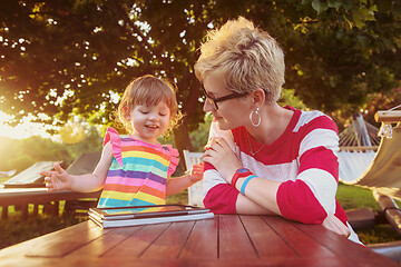 Image showing mom and her little daughter using tablet computer