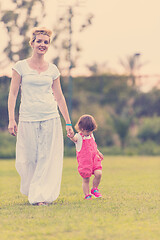 Image showing mother and little daughter playing at backyard