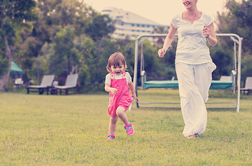 Image showing mother and little daughter playing at backyard