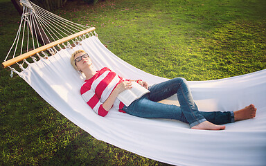 Image showing woman reading a book while relaxing on hammock