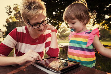 Image showing mom and her little daughter using tablet computer