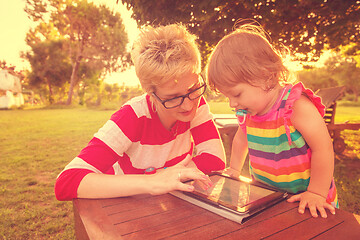 Image showing mom and her little daughter using tablet computer