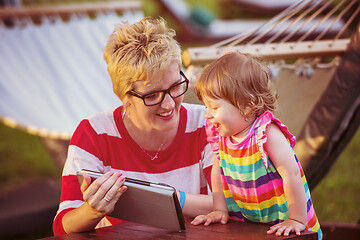 Image showing mom and her little daughter using tablet computer