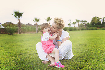 Image showing mother and little daughter playing at backyard