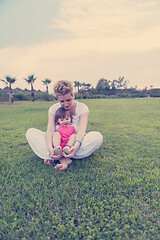 Image showing mother and little daughter playing at backyard