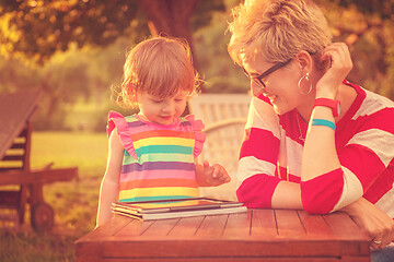 Image showing mom and her little daughter using tablet computer