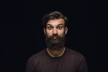 Image showing Close up portrait of young man isolated on black studio background