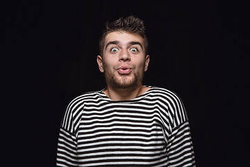 Image showing Close up portrait of young man isolated on black studio background