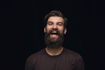 Image showing Close up portrait of young man isolated on black studio background