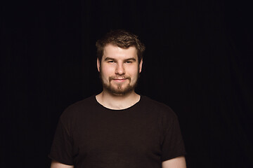 Image showing Close up portrait of young man isolated on black studio background