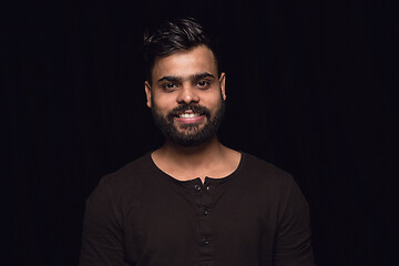 Image showing Close up portrait of young man isolated on black studio background