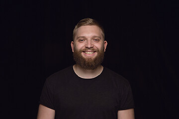 Image showing Close up portrait of young man isolated on black studio background