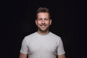 Image showing Close up portrait of young man isolated on black studio background