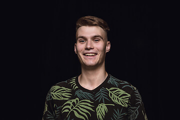 Image showing Close up portrait of young man isolated on black studio background