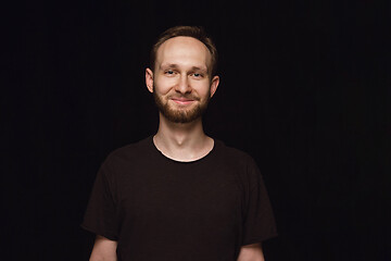 Image showing Close up portrait of young man isolated on black studio background