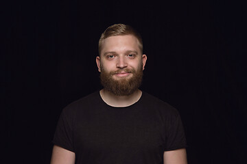 Image showing Close up portrait of young man isolated on black studio background