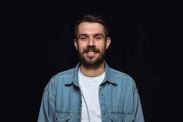 Image showing Close up portrait of young man isolated on black studio background