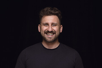 Image showing Close up portrait of young man isolated on black studio background