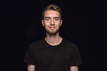 Image showing Close up portrait of young man isolated on black studio background
