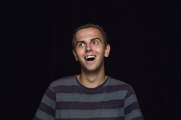 Image showing Close up portrait of young man isolated on black studio background