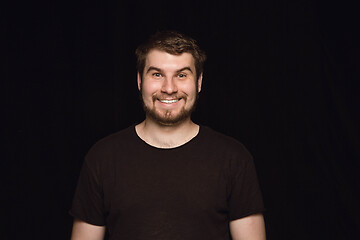 Image showing Close up portrait of young man isolated on black studio background