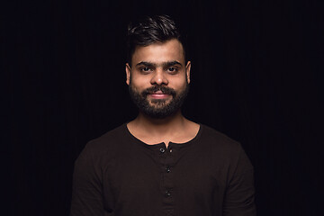 Image showing Close up portrait of young man isolated on black studio background