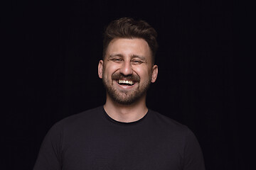 Image showing Close up portrait of young man isolated on black studio background