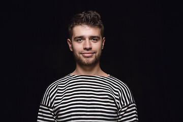 Image showing Close up portrait of young man isolated on black studio background