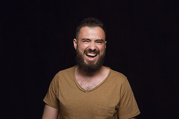 Image showing Close up portrait of young man isolated on black studio background