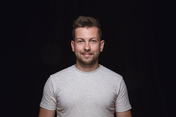 Image showing Close up portrait of young man isolated on black studio background