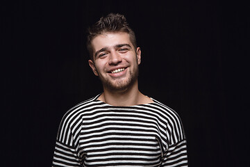 Image showing Close up portrait of young man isolated on black studio background