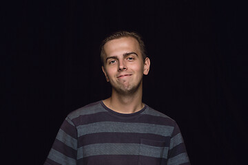 Image showing Close up portrait of young man isolated on black studio background