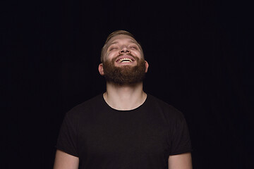 Image showing Close up portrait of young man isolated on black studio background