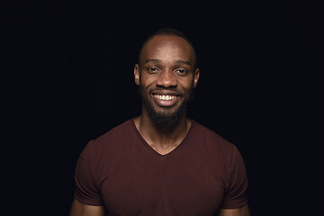 Image showing Close up portrait of young man isolated on black studio background