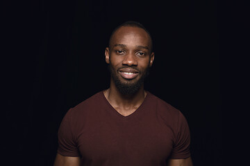 Image showing Close up portrait of young man isolated on black studio background