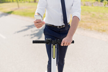 Image showing businessman with smartphone and electric scooter