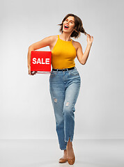 Image showing happy smiling young woman posing with sale sign