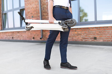 Image showing businessman with folding scooter on rooftop