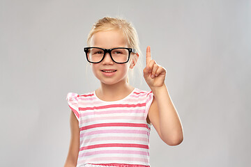 Image showing smiling little girl in glasses pointing finger up