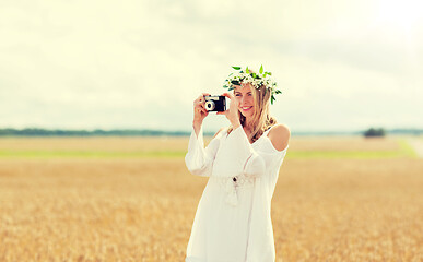 Image showing happy woman with film camera in wreath of flowers