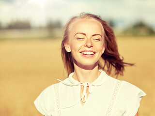 Image showing smiling young woman in white on cereal field