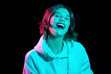 Image showing woman wearing hoodie in neon lights over black