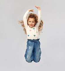 Image showing smiling little girl jumping