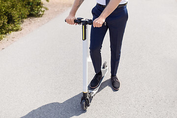 Image showing young businessman riding electric scooter outdoors