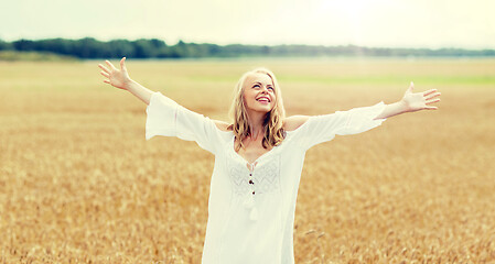 Image showing smiling young woman in white dress on cereal field